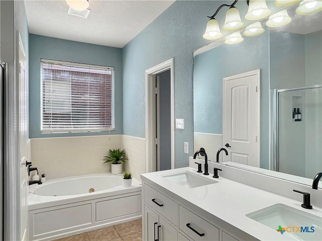 bathroom with vanity, tile patterned floors, shower with separate bathtub, and a textured ceiling