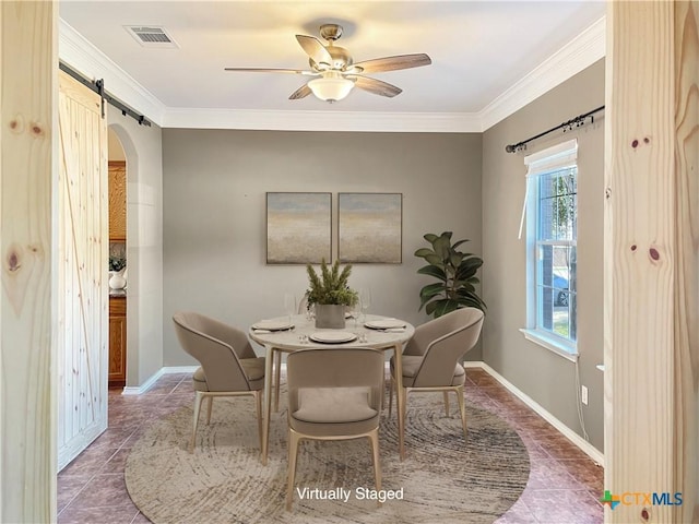 tiled dining room featuring crown molding, a barn door, and ceiling fan