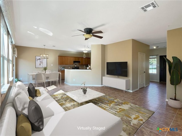 403 Red Hawk Dr, Leander, TX 78641 - living area featuring a ceiling fan, baseboards, tile patterned flooring, and a chandelier