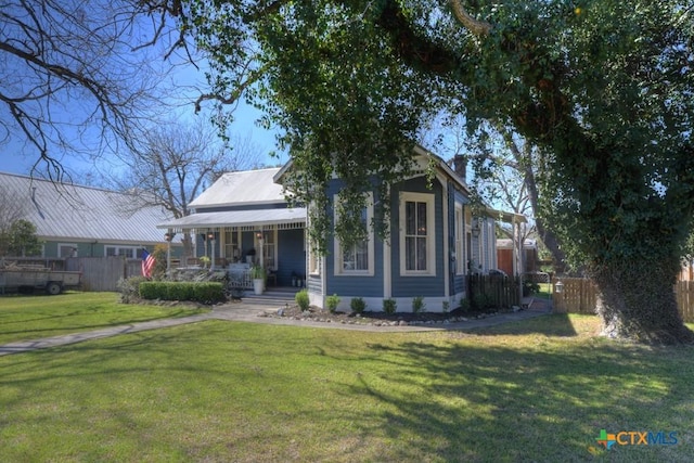 view of front of property with covered porch, a front lawn, and fence