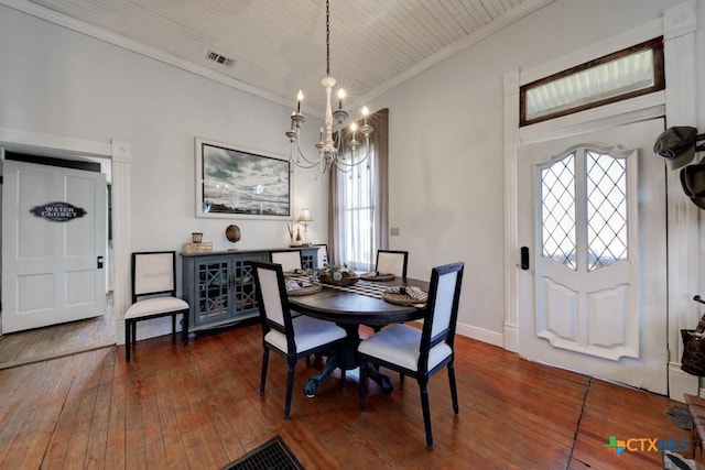 dining space with visible vents, baseboards, an inviting chandelier, hardwood / wood-style flooring, and crown molding