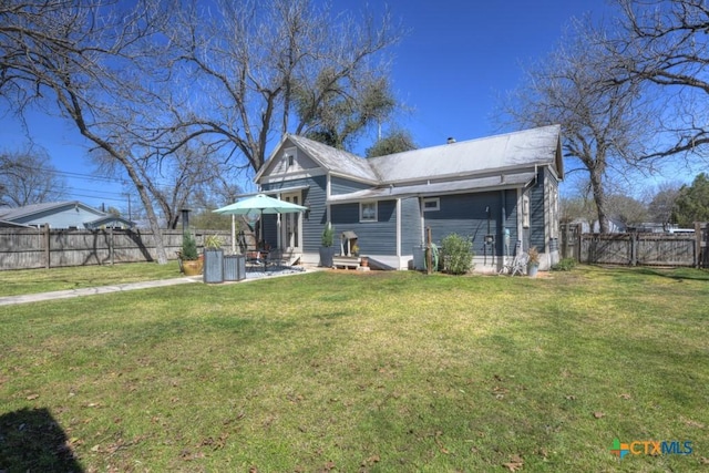 back of house featuring a gate, a patio area, a lawn, and a fenced backyard