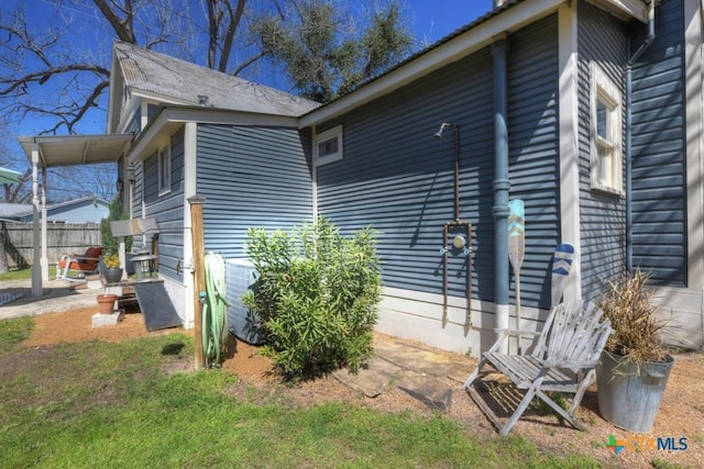 view of side of home featuring fence