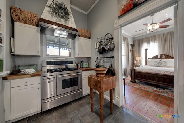 kitchen featuring white cabinetry, crown molding, range with two ovens, and premium range hood