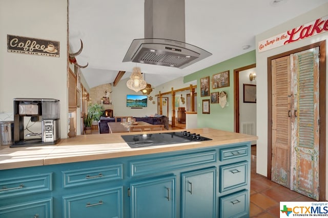 kitchen featuring island range hood, hanging light fixtures, blue cabinetry, vaulted ceiling with beams, and black stovetop