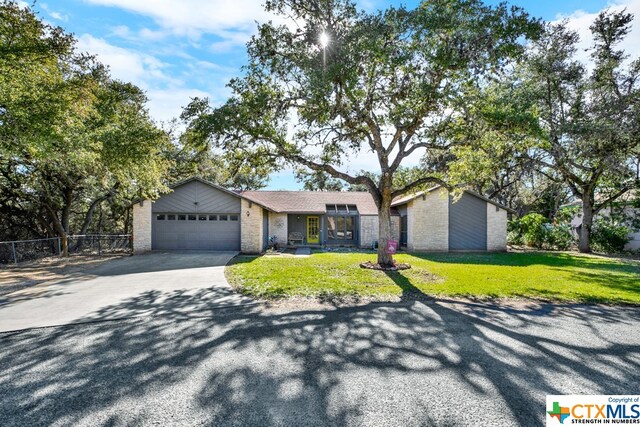 ranch-style home featuring a garage and a front lawn