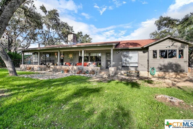 back of house with a lawn