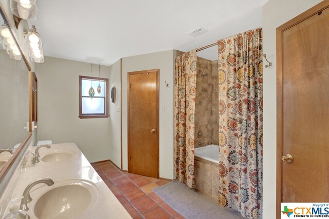 bathroom featuring vanity, tile patterned floors, and tiled tub