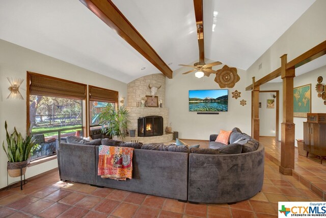 tiled living room featuring a stone fireplace, high vaulted ceiling, ceiling fan, and beam ceiling