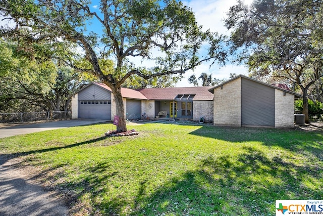 single story home featuring a garage, cooling unit, and a front yard