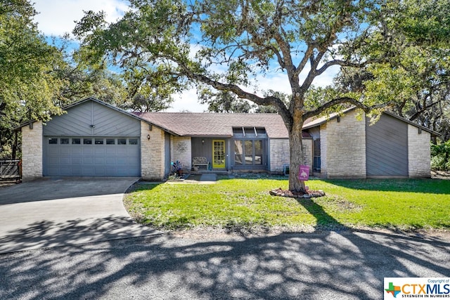 ranch-style house with a garage and a front yard