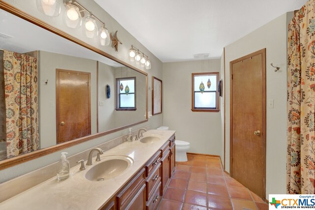 bathroom featuring tile patterned flooring, vanity, and toilet