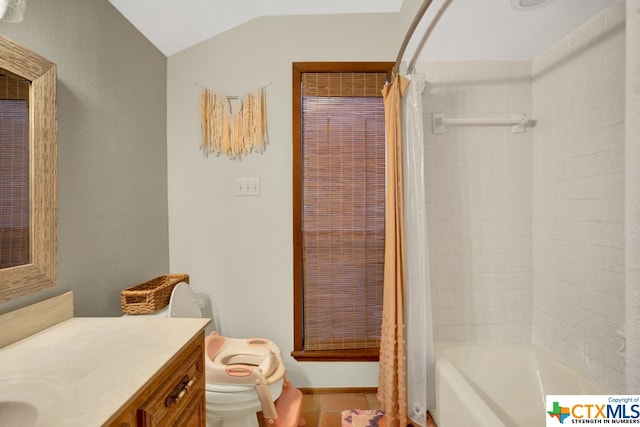 full bathroom with shower / tub combo with curtain, vanity, toilet, and vaulted ceiling