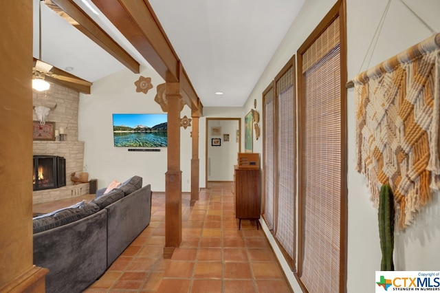 corridor featuring ornate columns, tile patterned floors, and vaulted ceiling with beams