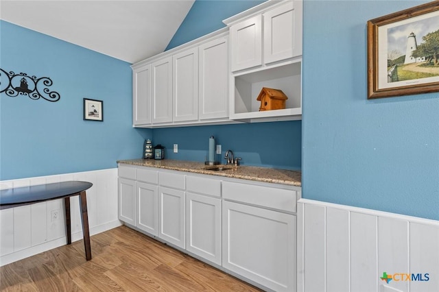 1605 Altavista Loop, Temple, TX 76502 - bar with a sink, wainscoting, vaulted ceiling, and light wood-style flooring