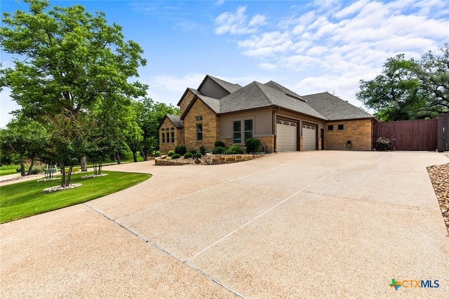 1605 Altavista Loop, Temple, TX 76502 - view of front of home featuring stone siding, a garage, driveway, and a shingled roof