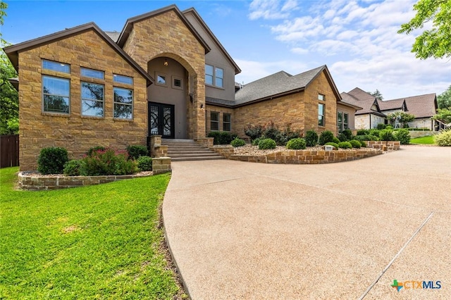 1605 Altavista Loop, Temple, TX 76502 - view of front of house featuring stone siding, a front yard, and french doors