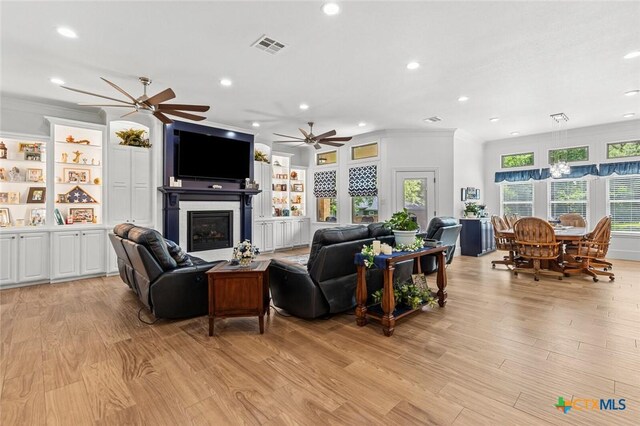 1605 Altavista Loop, Temple, TX 76502 - living area with recessed lighting, a glass covered fireplace, ceiling fan, light wood-type flooring, and crown molding