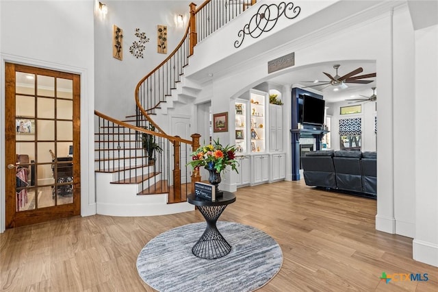 1605 Altavista Loop, Temple, TX 76502 - entrance foyer featuring a ceiling fan, a fireplace, light wood-type flooring, stairway, and a high ceiling