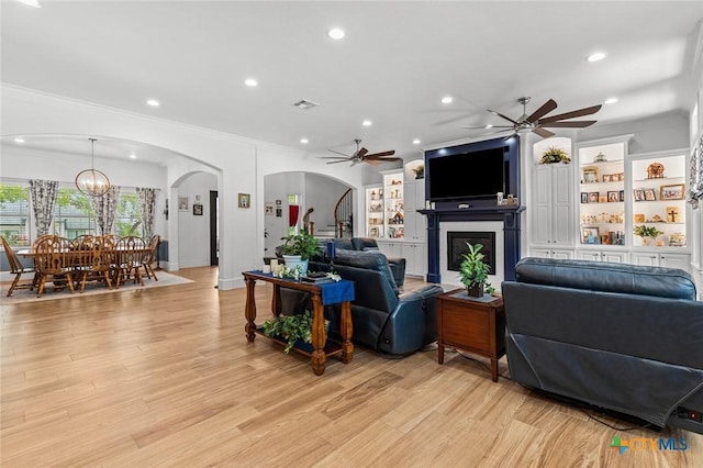 1605 Altavista Loop, Temple, TX 76502 - living room with arched walkways, crown molding, ceiling fan, recessed lighting, and a fireplace