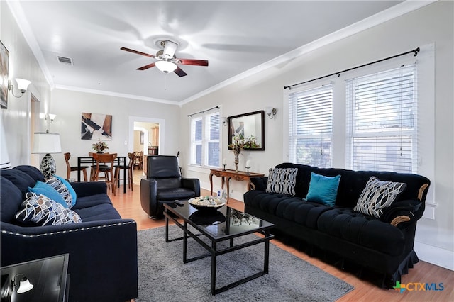 living room with ceiling fan, wood-type flooring, and ornamental molding