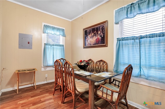 dining room featuring electric panel, hardwood / wood-style flooring, and crown molding