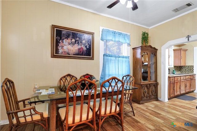 dining room with ornamental molding, light hardwood / wood-style flooring, ceiling fan, and sink