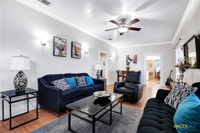 living room with ornamental molding, hardwood / wood-style flooring, and ceiling fan