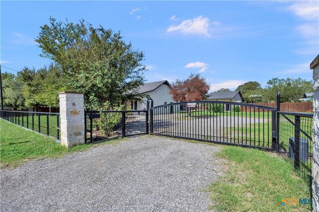 view of gate with a yard and fence