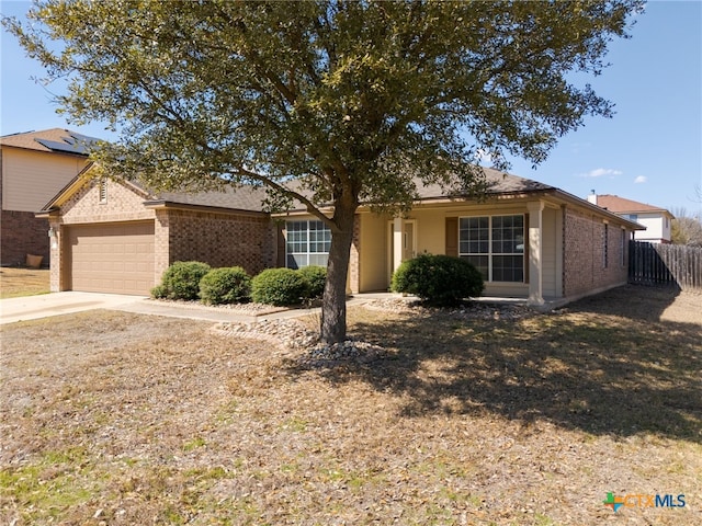 single story home with an attached garage, driveway, fence, and brick siding