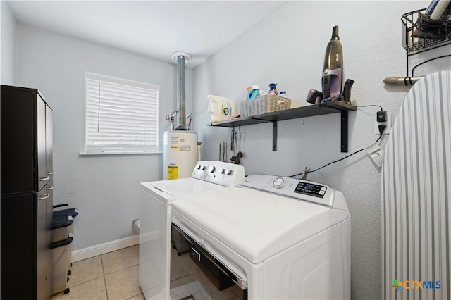 clothes washing area featuring water heater, washing machine and clothes dryer, and light tile patterned floors