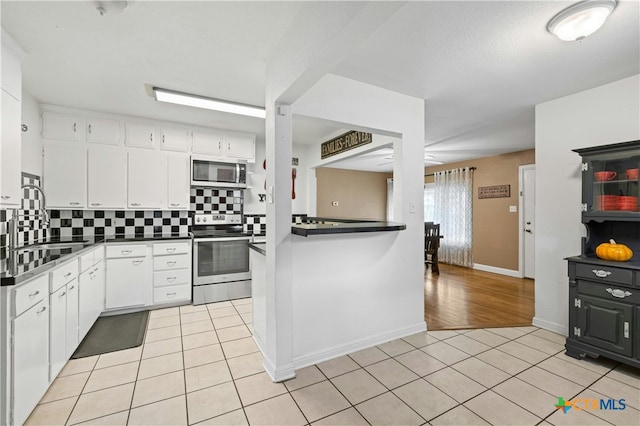 kitchen featuring backsplash, appliances with stainless steel finishes, sink, and white cabinets