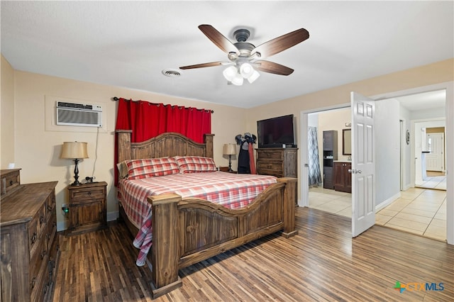 bedroom featuring a wall mounted AC, hardwood / wood-style floors, and ceiling fan