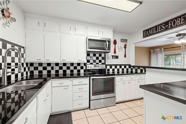 kitchen featuring light tile patterned flooring, stainless steel appliances, white cabinetry, backsplash, and sink