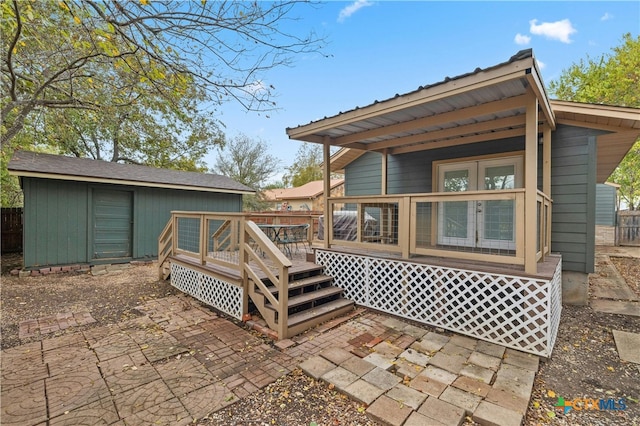 back of property featuring a deck, a storage unit, and a patio area