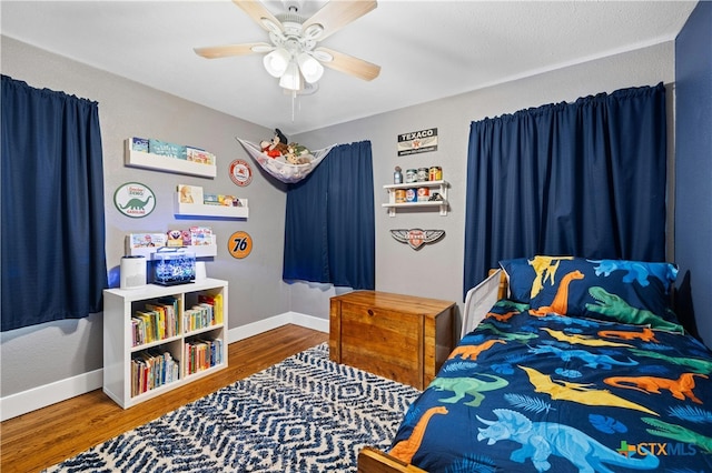 bedroom featuring hardwood / wood-style flooring, a textured ceiling, and ceiling fan