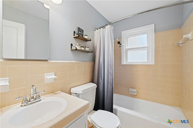 full bathroom with tile walls, vanity, toilet, and shower / bathtub combination with curtain