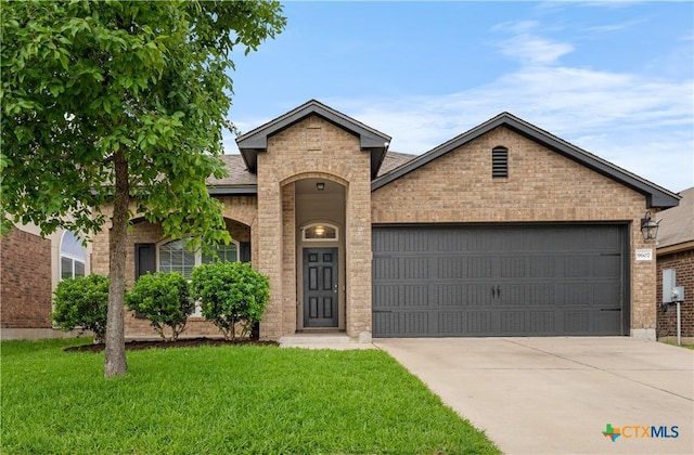 traditional home featuring brick siding, an attached garage, driveway, and a front yard