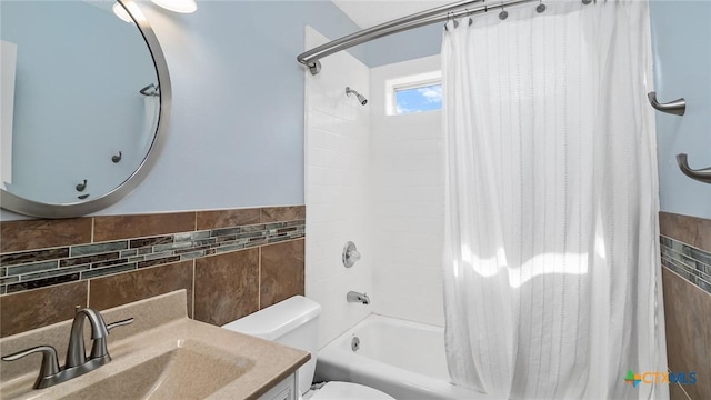 full bathroom featuring vanity, toilet, shower / bathtub combination with curtain, and tile walls