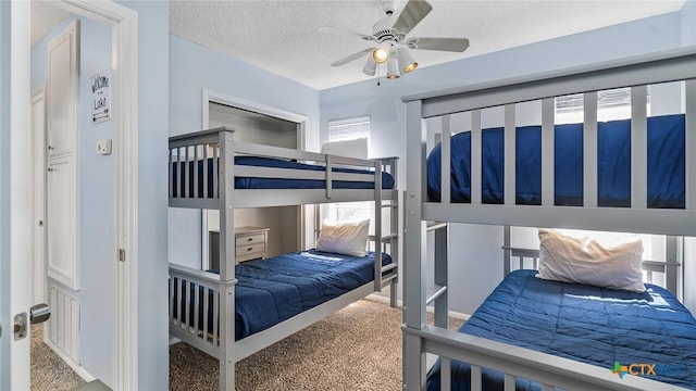 bedroom featuring multiple windows, ceiling fan, carpet floors, and a textured ceiling