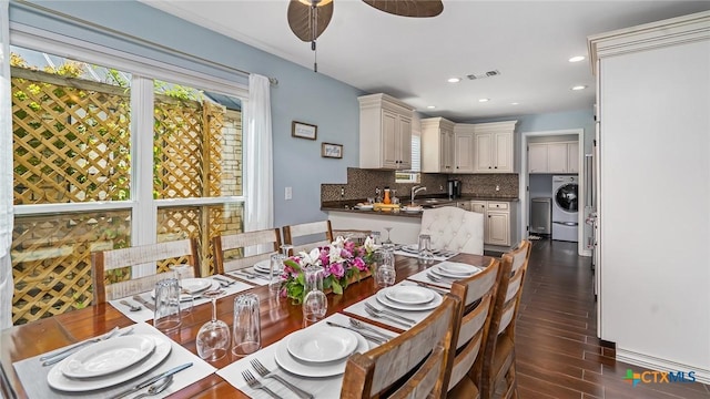 dining room featuring washer / dryer, dark hardwood / wood-style floors, and sink