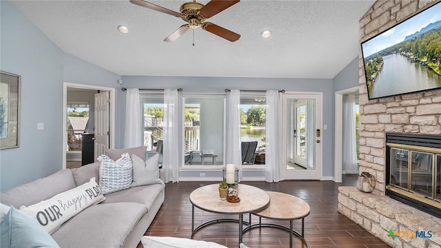 living room with a textured ceiling, vaulted ceiling, and a healthy amount of sunlight