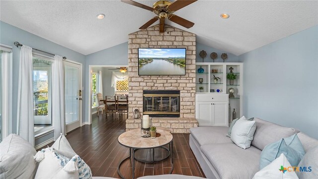 living room featuring dark hardwood / wood-style floors, a fireplace, a textured ceiling, and vaulted ceiling