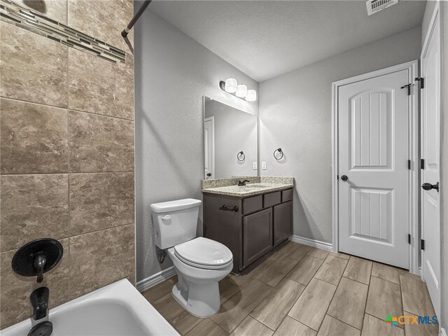 5205 Colina Dr, Killeen, TX 76549 - full bath with vanity, wood tiled floors, toilet, bathing tub / shower combination, and a textured wall