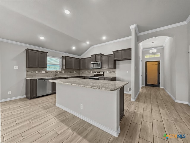 5205 Colina Dr, Killeen, TX 76549 - kitchen with stainless steel appliances, wood tiled floors, arched walkways, a kitchen island, and decorative backsplash