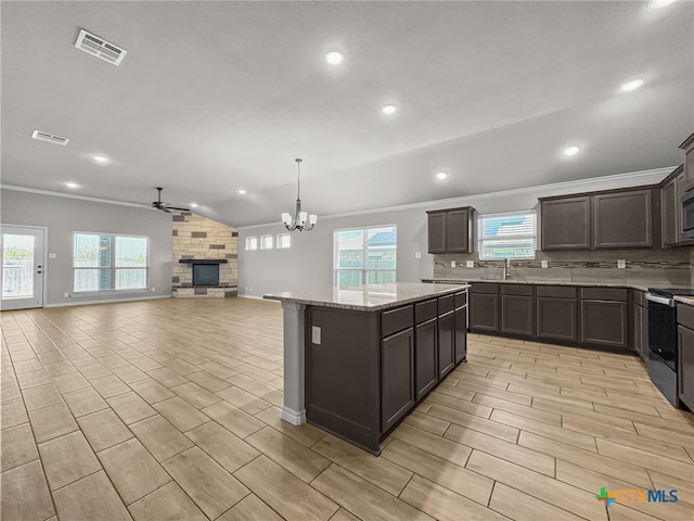 5205 Colina Dr, Killeen, TX 76549 - kitchen featuring a ceiling fan, crown molding, stainless steel range with electric stovetop, a kitchen island, and a fireplace
