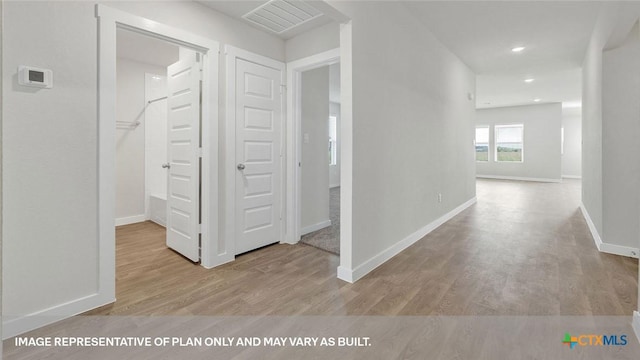 corridor with light hardwood / wood-style floors