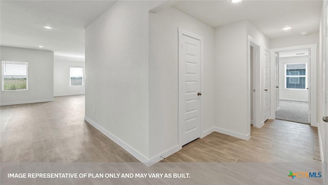 hallway with light hardwood / wood-style floors