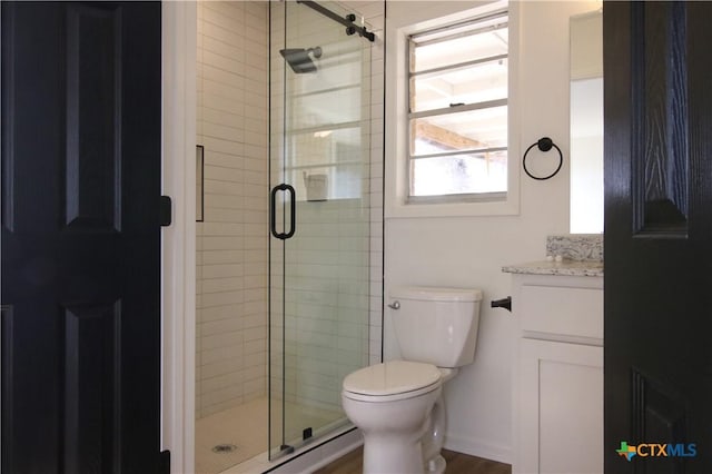 full bath featuring vanity, a shower stall, and toilet