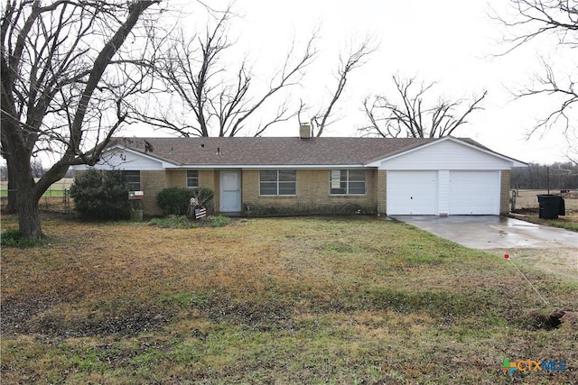 single story home featuring brick siding, a front lawn, concrete driveway, a chimney, and a garage